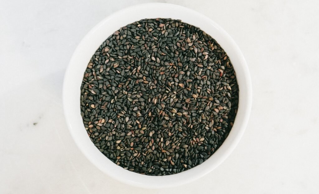 Spoon and bowl filled with black sesame seeds